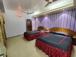 1 Schlafzimmer mit 2 Betten und einer lila Wand in der Unterkunft Asian SR Hotel in Chittagong