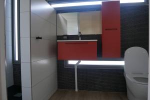 baño con lavabo rojo y aseo en Villa Kumquat, avec piscine Clévacances 4 clés, en Petit-Bourg