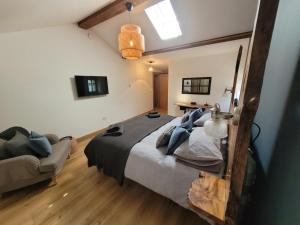 een slaapkamer met een groot bed en een bank bij Loch Lomond Blair Byre in Rowardennan