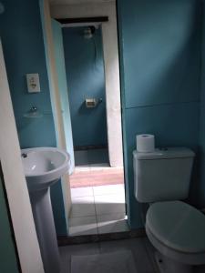 a blue bathroom with a toilet and a sink at Estância Verde in Valença