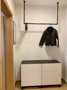 a white cabinet with a sweater hanging on a wall at Appartement Lilienthal in Klagenfurt
