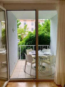 een glazen deur naar een balkon met een tafel en stoelen bij Appartement Lilienthal in Klagenfurt