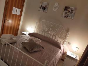 een slaapkamer met een bed met 2 kussens erop bij Affittacamere Lo Scoiattolo di Mannocchi Lorella in Porto SantʼElpidio
