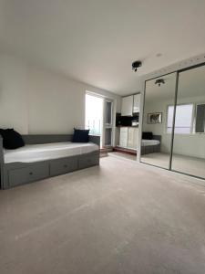 a large bedroom with a bed and a large mirror at Roof Garden Flat in London