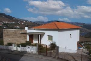 une petite maison blanche avec un toit orange dans l'établissement Cantinho da Quintã, à Mesão Frio