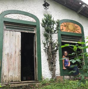 una mujer sentada en una ventana de una casa en Estância Verde, en Valença