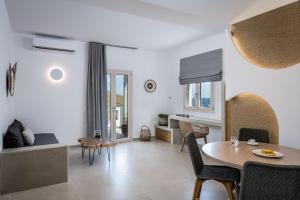 a dining room and living room with a table and chairs at Remezzo Bayfront Suites in Livadi Astypalaias