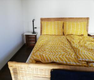 a bed with yellow and white sheets and a night stand at Your Suite Runkel - Runkel, you're sweet! in Runkel