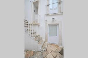 biały budynek ze schodami i drzwiami w obiekcie GaDa Home -centro storico - w mieście Martina Franca