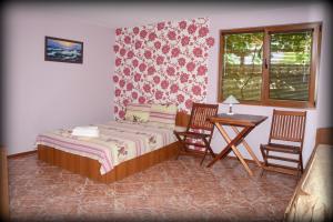 a bedroom with a bed and a table and two chairs at Лорета-Камен бряг in Kamen Bryag