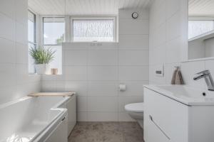 a white bathroom with a sink and a toilet at 4 Bedroom Archipelago Retreat in Tranholmen +24 photos