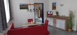 sala de estar con silla roja y mesa en Apartment Auszeit en Kirchberg an der Pielach