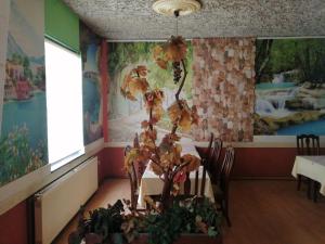 a dining room with a table with a plant on it at Apartmani i sobe Okuka in Višegrad