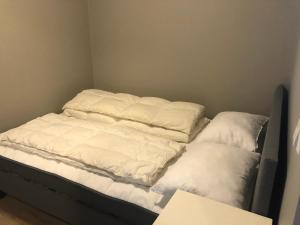 Una cama sin hacer con dos almohadas encima. en Sjønær Idyll, en Kristiansand