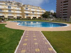 a swimming pool in front of a large building at Sunset Village Apartment - Brisa Da Ericeira in Ericeira