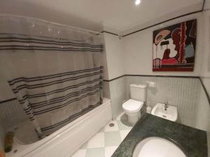 a bathroom with a tub and a toilet and a sink at Sunset Village Apartment - Brisa Da Ericeira in Ericeira