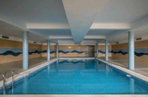a swimming pool with blue water in a building at Sunset Village Apartment - Brisa Da Ericeira in Ericeira +2 photos