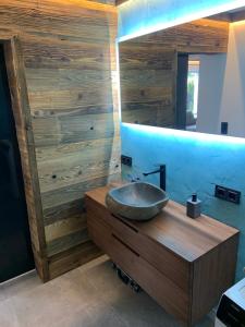 ein Badezimmer mit einem Waschbecken und einer Holzwand in der Unterkunft Kitz Kaiser Appartement in Sankt Johann in Tirol