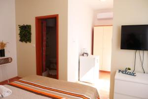 a living room with a flat screen tv on a wall at Apartment and Rooms Vilma in Fažana