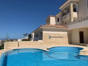 a large swimming pool in front of a house at Beau Views Seven in Peyia