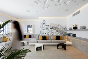 a living room with a couch and a wall mural at Kouros Village Hotel - Adults Only in Perissa