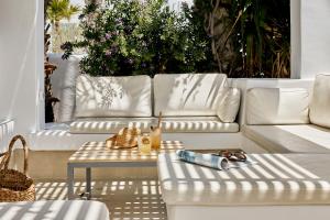 a living room with a white couch and a table at Kouros Village Hotel - Adults Only in Perissa