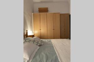 Un dormitorio con una cama y un armario de madera. en Casa Buenos Aires, en Punta Grossa 21 fotos más