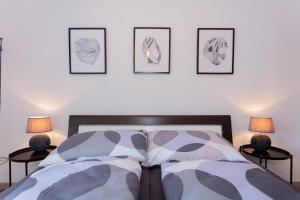 - une chambre dotée d'un lit avec 3 photos sur le mur dans l'établissement Ferienwohnung im Zentrum, à Maria Alm