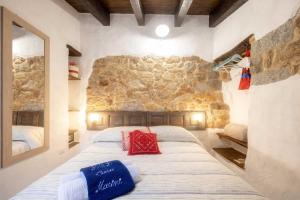 a bedroom with a large bed with a stone wall at Casa Masini Authentic Barbagia Boutique Stay in Fonni