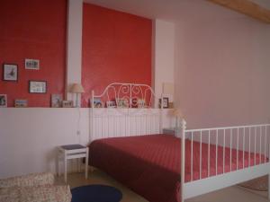a bedroom with a bed with a red wall at Santo António's Guesthouse in Cascais