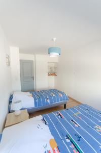 een slaapkamer met 2 bedden en een tapijt op de vloer bij VILLA LA FORT BELLE VUE in Ambleteuse