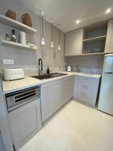 uma cozinha com armários brancos e um lavatório em MAISON NOMADE Valbonne em Valbonne