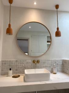 ein Bad mit einem Waschbecken und einem Spiegel in der Unterkunft MAISON NOMADE Valbonne in Valbonne