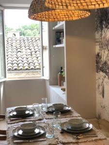 uma mesa com pratos e copos e uma janela em MAISON NOMADE Valbonne em Valbonne