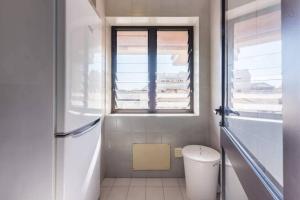 ein weißes Bad mit einem Fenster und einem WC in der Unterkunft Gaia House - Apartamento Inteiro junto ao Metro in Vila Nova de Gaia