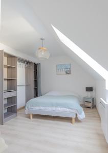 een witte slaapkamer met een bed en een trap bij VILLA LA FORT BELLE VUE in Ambleteuse