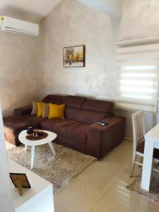 sala de estar con sofá marrón y mesa en Apartmani Stijepovic, en Podgorica