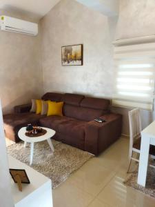 a living room with a brown couch and a table at Apartmani Stijepovic in Podgorica