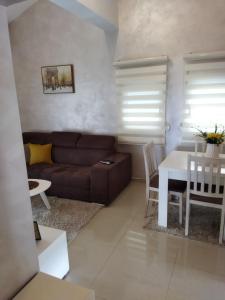 uma sala de estar com um sofá e uma mesa em Apartmani Stijepovic em Podgorica