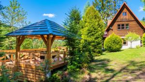 a wooden gazebo in front of a log house at Ostoja Rycerka in Rycerka Górna