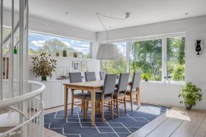 a dining room with a wooden table and chairs at 4 Bedroom Archipelago Retreat in Tranholmen