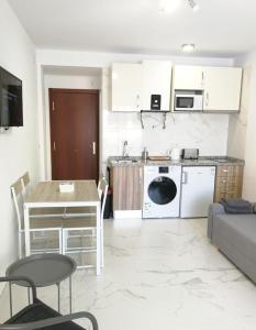 a kitchen and living room with a table and a couch at Babylon Tourist Apartments in Benalmádena