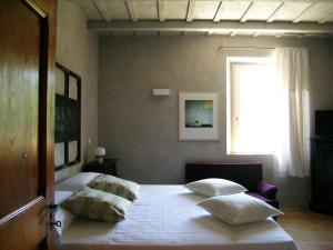 Un dormitorio con una cama con almohadas. en Tuttaterra, en Serra San Quirico