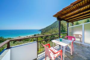 a balcony with a table and chairs and the ocean at Studios Niki in Koinyra