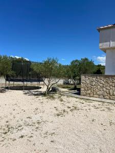 - un parc avec un mur en pierre et un panier de basket dans l'établissement Kuća za miran odmor - Sukošan, à Sukošan