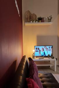 sala de estar con sofá y TV de pantalla plana en Ercole' s Home, en Caserta