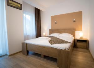 a bedroom with a large bed with white sheets and pillows at Vila 27 in Eforie Nord
