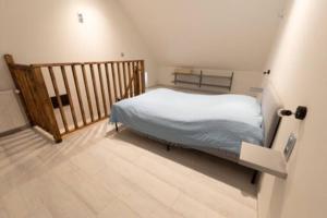 a small bedroom with a bed and a wooden floor at Loft bourguignon au pied des sources de la Seine in Chanceaux