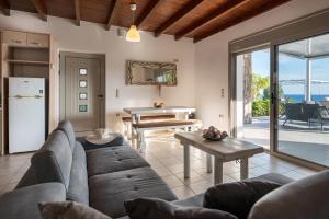 ein Wohnzimmer mit einem Sofa und einem Tisch in der Unterkunft Achlia Beach Villa in Achlia