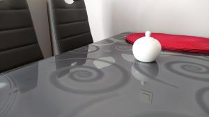 a glass table with a white vase on top of it at Apartamenty Przemko in Rewal
